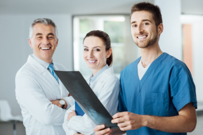 Three doctors smiling at the camera
